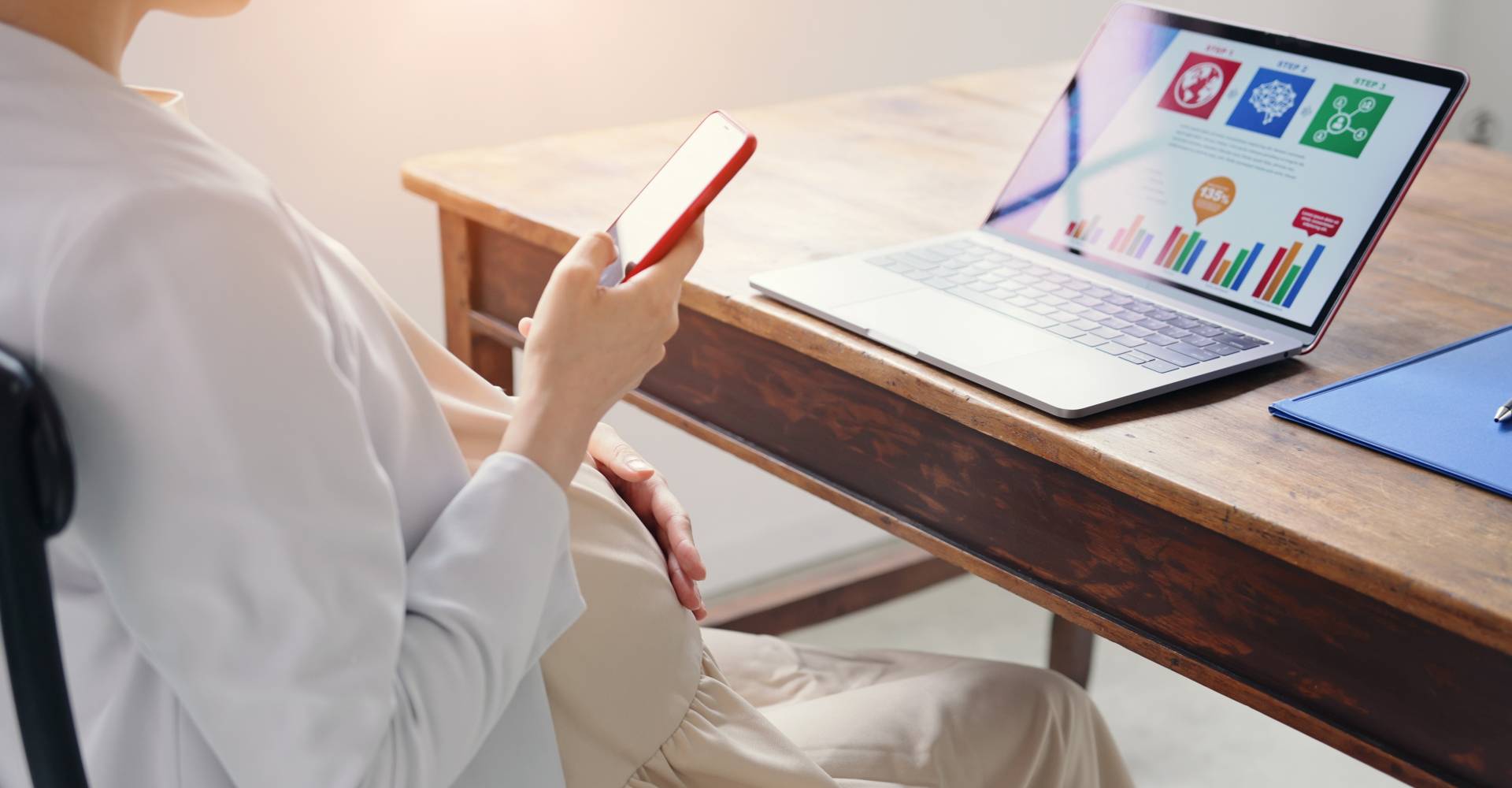 Manager using a laptop and smartphone in the process of solution development